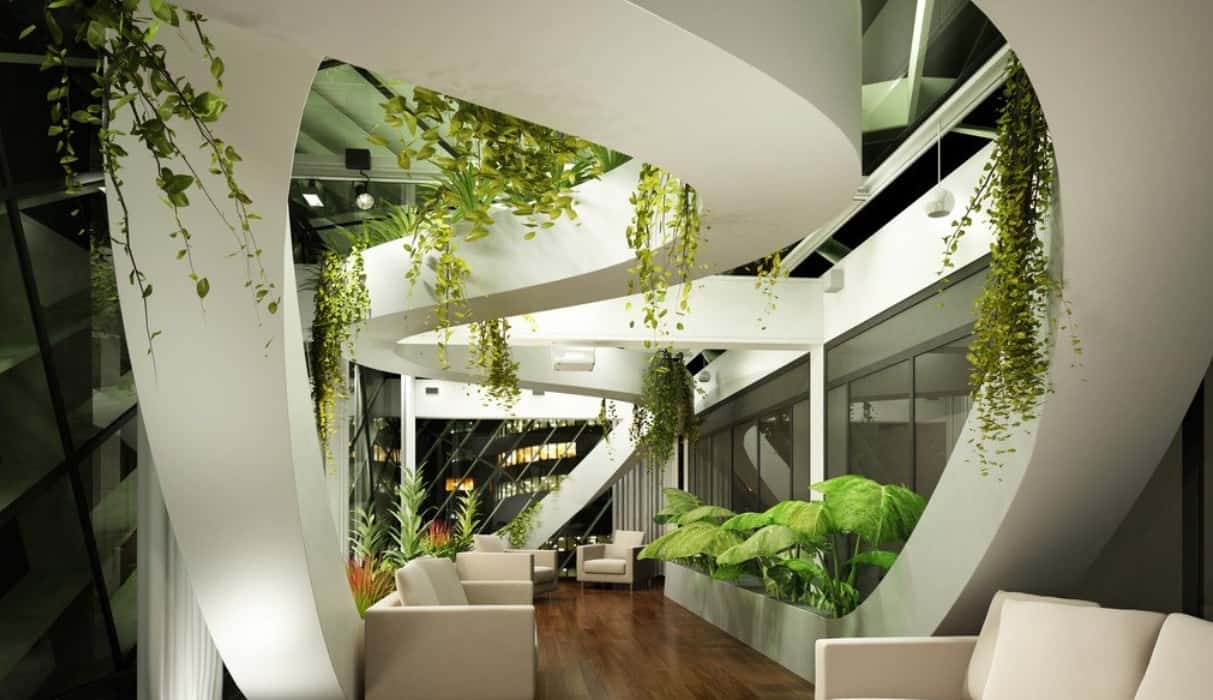 a modern building entryway with seating and many hanging and potted plants